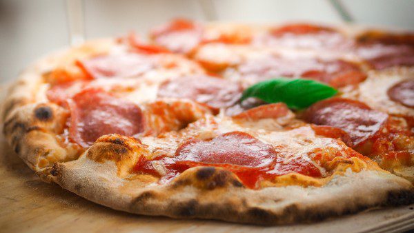 Freshly cooked pizza with a basil leaf on top